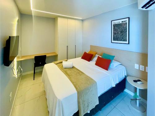 a bedroom with a bed with white sheets and red pillows at Aquarius Style by Holiday Stays in Fortaleza