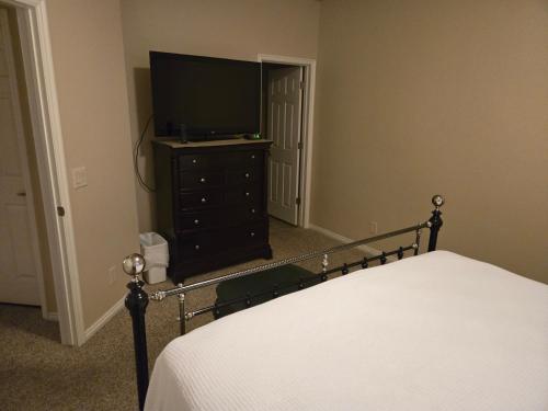 a bedroom with a bed and a television on a dresser at Mesquite Nevada Vacation Rental - Ground Level and double car garage in Mesquite