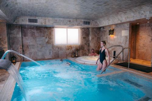 a woman is standing in a hot tub at Palacio del Inka, a Luxury Collection Hotel, Cusco in Cusco