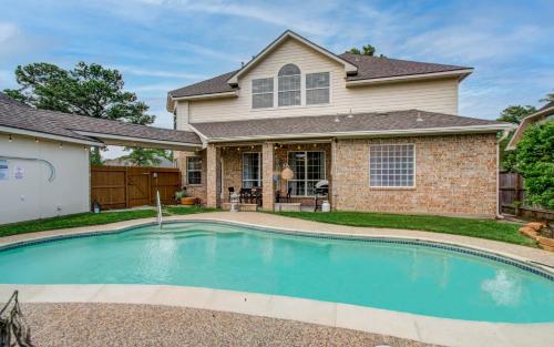 a swimming pool in front of a house at Big Texas Living - Spacious 5-BD with Pool in Cypress