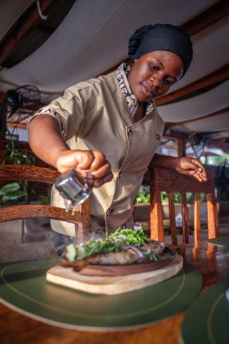 a man is preparing food on a cutting board at The Bali Resort Zanzibar in Pingwe