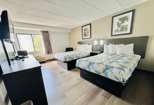 a hotel room with two beds and a desk at Motel 6-Milford, CT in Milford