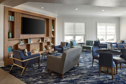 a waiting room with chairs and a flat screen tv at Residence Inn by Marriott Raleigh Crabtree Valley in Raleigh