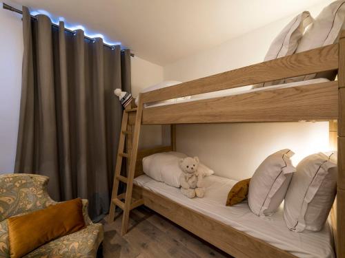 a bunk bed with a teddy bear sitting on the bottom bunk at Appartement de standing à Courchevel avec vue, proche des pistes, parking inclus - FR-1-575-59 in Courchevel