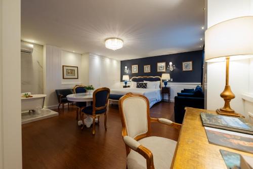 a hotel room with a bed and a table and chairs at Villa do Vale Boutique Hotel in Blumenau