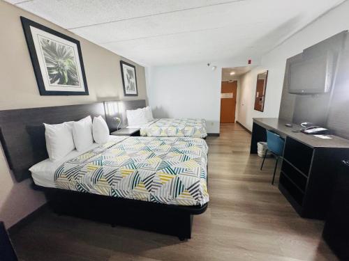 a hotel room with two beds and a desk at Motel 6-Milford, CT in Milford