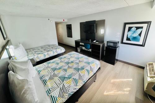 a hotel room with two beds and a desk at Motel 6-Milford, CT in Milford