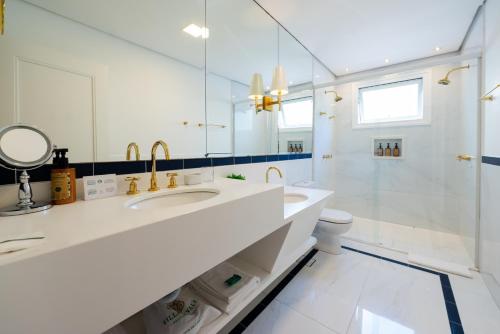 a white bathroom with a sink and a mirror at Villa do Vale Boutique Hotel in Blumenau