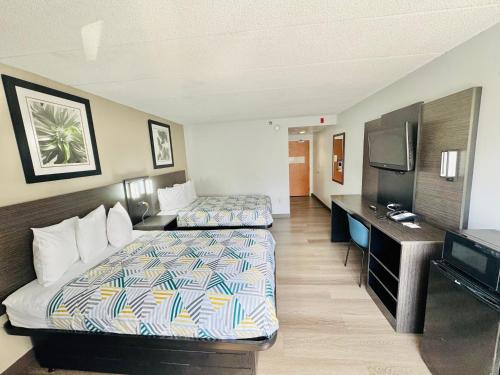 a hotel room with two beds and a flat screen tv at Motel 6-Milford, CT in Milford