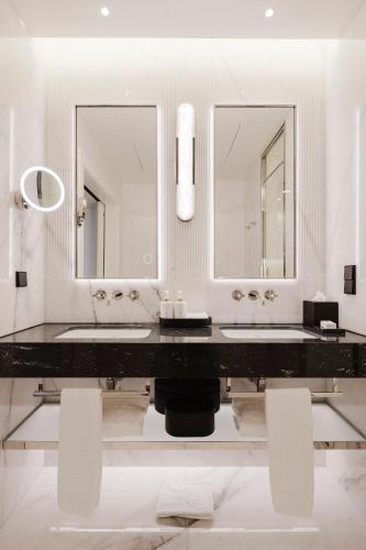 a bathroom with two sinks and two mirrors at Lisbon Chiado Hotel & Spa in Lisbon