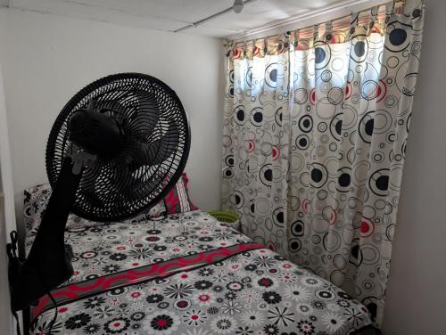 a bedroom with a fan sitting on a bed at English power Exotic point in Barranquilla