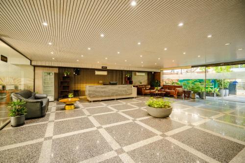 a large lobby with a couch and chairs and tables at Royal Studio Golf Course Road in Gurgaon