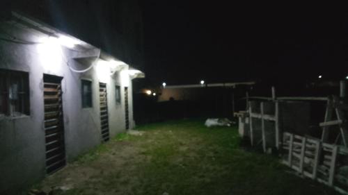 a dog laying on the grass next to a building at night at Leo y mar in Mar de Ajó