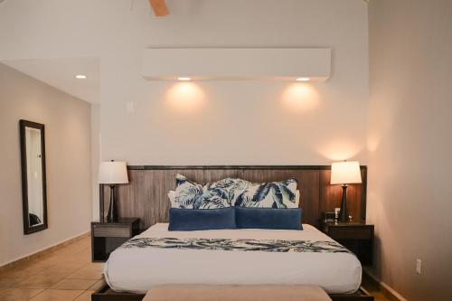 a bedroom with a large bed with blue pillows at St. James's Club Resort - All Inclusive in English Harbour Town