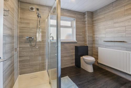 a bathroom with a shower and a toilet at The Beach House - North East Escapes in Whitley Bay