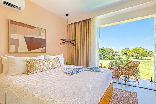a bedroom with a bed and a large window at Elegant Cocotal 2BD Condo in Punta Cana