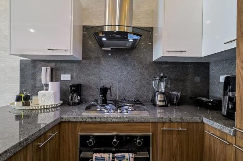 a kitchen with white cabinets and a stove top oven at Lovely 1BR Apt, King Bed, Pool in La Julia