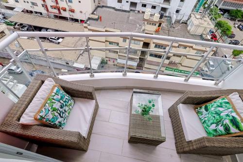 two wicker chairs sitting on top of a balcony at Lovely 1BR Apt, King Bed, Pool in La Julia