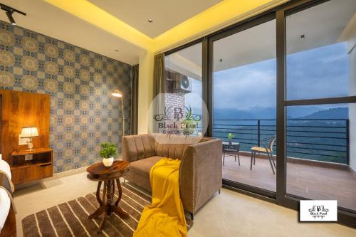 a living room with a couch and a balcony at The BlackPearl Hillcrest in Kasauli