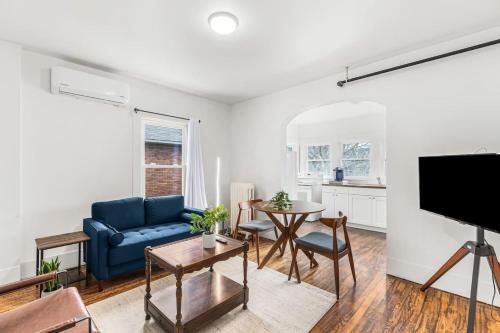 a living room with a blue couch and a table at Luxury Holbrook Apartment in Detroit