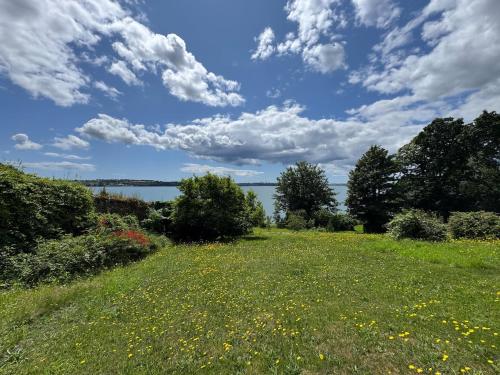 a field of grass with a view of the water at The Arches, Georgian Apartment in Cobh