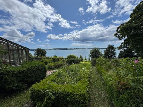a garden with a view of the water at The Arches, Georgian Apartment in Cobh