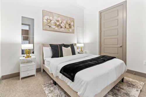 a white bedroom with a large bed and two lamps at Cozy Hideaway, Rooftop Pool, Gym, Shops nearby in Georgetown
