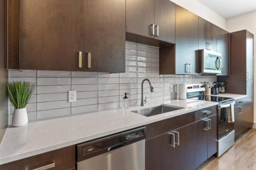 a kitchen with wooden cabinets and a sink at Modern Luxe Oasis, Rooftop Pool, Near Austin in Georgetown