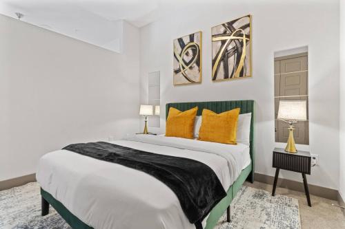 a bedroom with a large bed with yellow pillows at Modern Luxe Oasis, Rooftop Pool, Near Austin in Georgetown