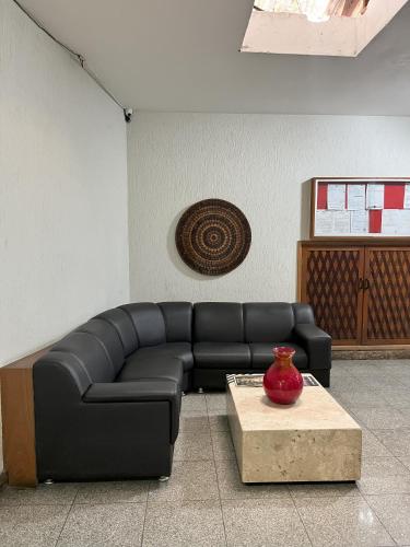 a black leather couch in a room with a table at Status Elegance Hotel in Serra