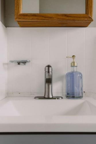 a sink with a soap dispenser and a bottle on it at Westlake Getaway Apartment in Westlake