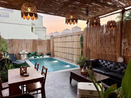 a swimming pool in a backyard with a couch and a table at Western Townhouse with swimming pool in Ras al Khaimah