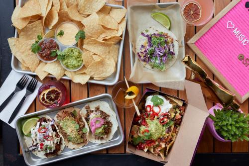 a table with three plates of food and tortilla chips at Moxy Louisville Downtown in Louisville