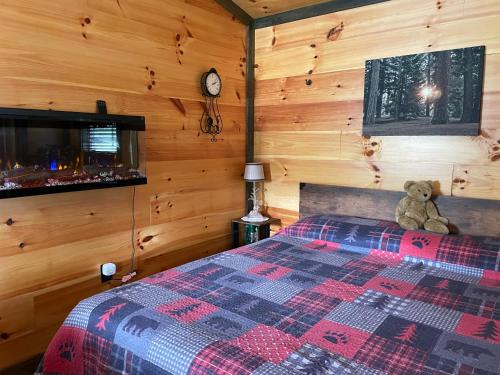 a teddy bear sitting on a bed in a room at Lily Pad Cabin in South Park