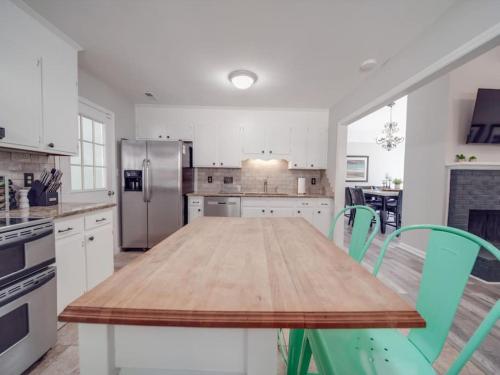 a kitchen with a wooden table and green chairs at Cozy 3BR Bungalow - City Views - Firepit -Football in Charlotte