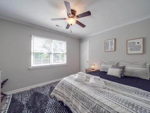 a bedroom with two beds and a ceiling fan at Cozy 3BR Bungalow - City Views - Firepit -Football in Charlotte
