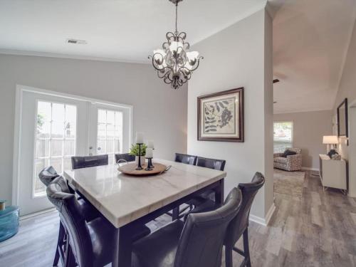 a dining room with a table with chairs and a chandelier at Cozy 3BR Bungalow - City Views - Firepit -Football in Charlotte