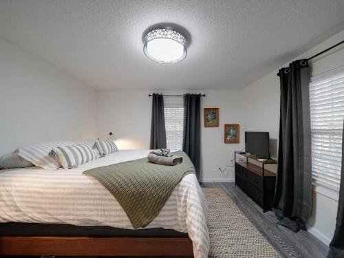 Un dormitorio con una cama grande y un televisor. en Warm Days and Cool Knights Fire Pit Boat Rental, en Mayhew