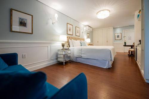 a bedroom with a bed and a table and chairs at Villa do Vale Boutique Hotel in Blumenau
