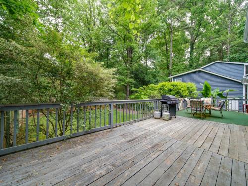 a wooden deck with a table and a grill at 4 BR South Charlotte Getaway Min to Everything in Charlotte