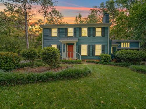 a blue house with a red door in a yard at 4 BR South Charlotte Getaway Min to Everything in Charlotte