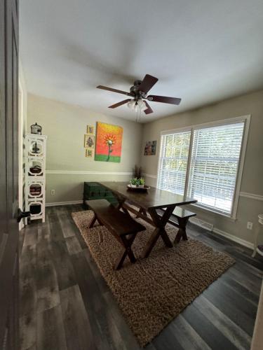 a dining room with a table and a ceiling fan at 4 BR South Charlotte Getaway Min to Everything in Charlotte
