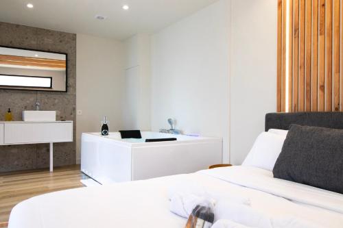a white bedroom with a bed and a desk at Domaine du Rondia - Chambres d'hôtes et Wellness in Wanze