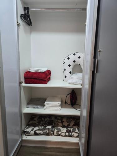 - un dressing avec des étagères blanches et des serviettes dans l'établissement Studios Centro SP 16, à São Paulo