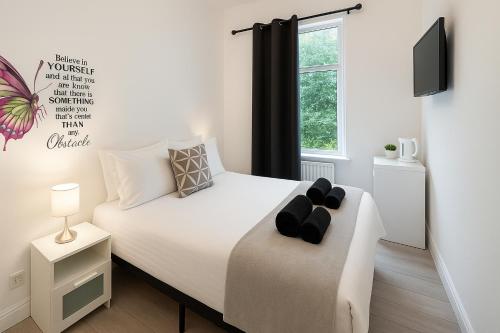 a bedroom with a white bed and a window at Shalom Stay London in London
