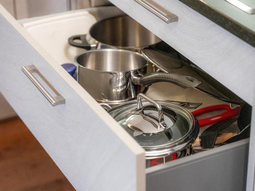 a kitchen stove with pots and pans in a drawer at Cricerhaus in Visp
