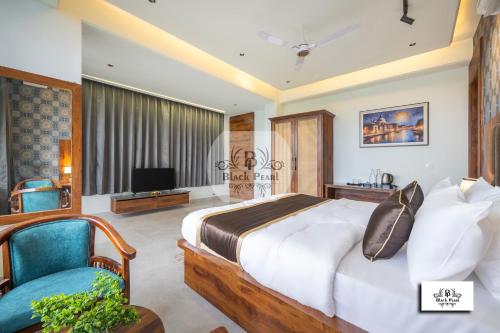 a bedroom with a large bed and a blue chair at The BlackPearl Hillcrest in Kasauli