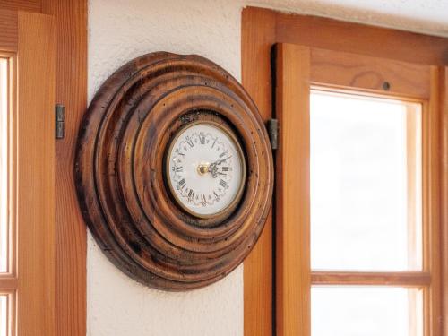 a wooden clock on the wall next to a door at Cricerhaus in Visp