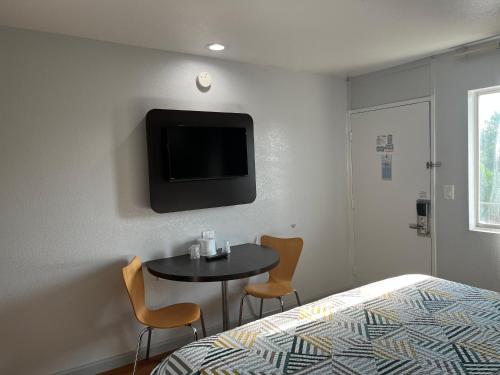 a room with a bed and a table and a tv at Motel 6 Dallas, TX – St. Augustine / HWY 175 in Dallas