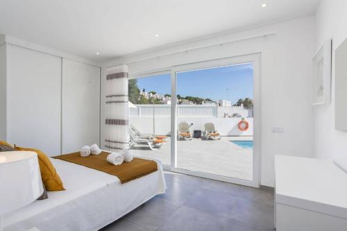 Un dormitorio con una cama y vistas a una piscina. en Villa Dona Leonor by Villa Plus, en Carvoeiro